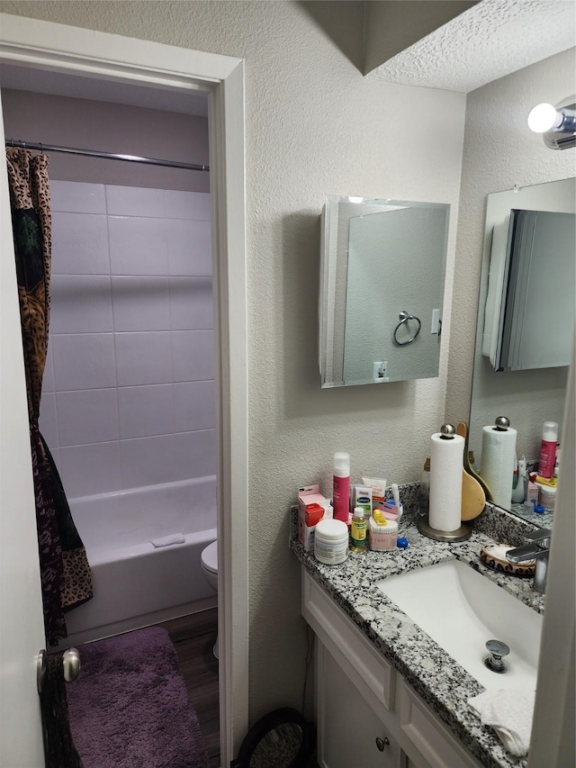 full bathroom with shower / bath combo, hardwood / wood-style floors, vanity, and toilet