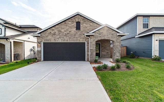10791 Sora Dr, Willis, TX 77378 - french country home with a front yard, brick siding, an attached garage, and driveway