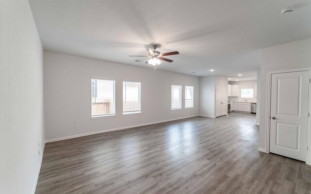 10791 Sora Dr, Willis, TX 77378 - unfurnished living room featuring ceiling fan, recessed lighting, baseboards, and wood finished floors