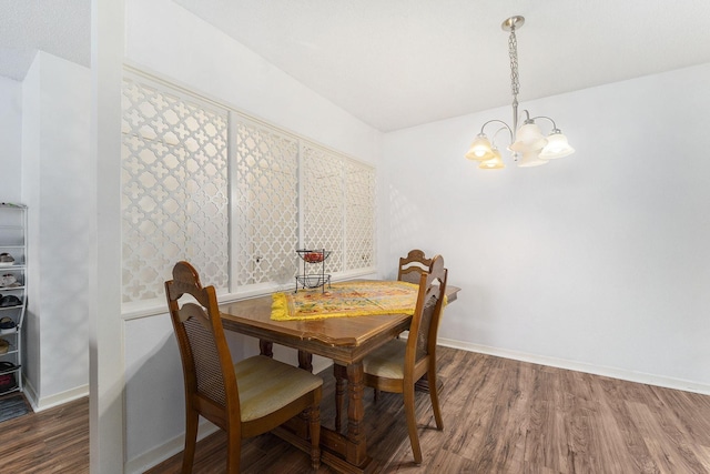 dining area featuring hardwood / wood-style flooring and a notable chandelier