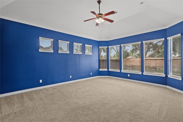 empty room featuring lofted ceiling, ornamental molding, ceiling fan, and carpet