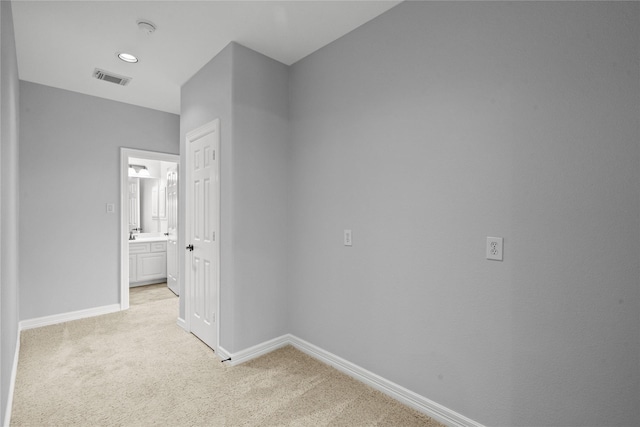 hallway featuring sink and light colored carpet