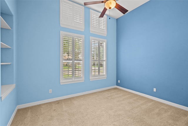 carpeted empty room featuring ceiling fan