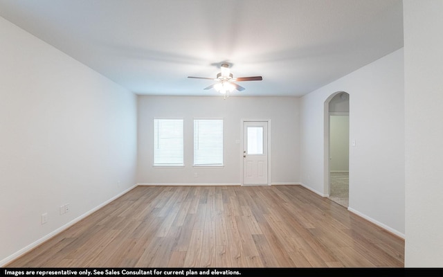 empty room with ceiling fan and light hardwood / wood-style floors