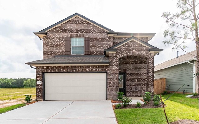 10775 Sora Dr, Willis, TX 77378 - traditional-style house featuring driveway, brick siding, a garage, a shingled roof, and a front yard