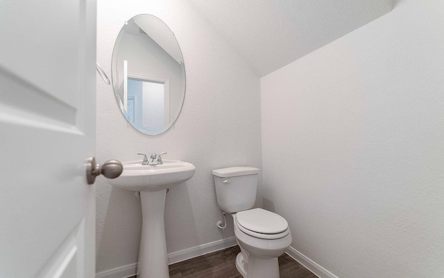 10775 Sora Dr, Willis, TX 77378 - half bath featuring lofted ceiling, baseboards, toilet, a sink, and wood finished floors