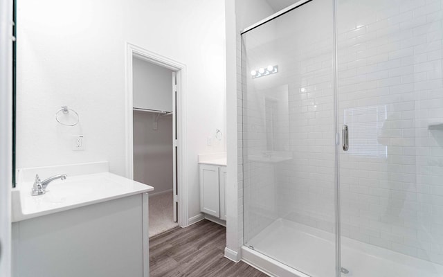10775 Sora Dr, Willis, TX 77378 - full bathroom with a stall shower, a walk in closet, vanity, and wood finished floors