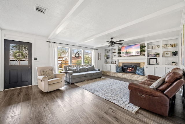 living room featuring visible vents, beam ceiling, a textured ceiling, wood-type flooring, and a fireplace