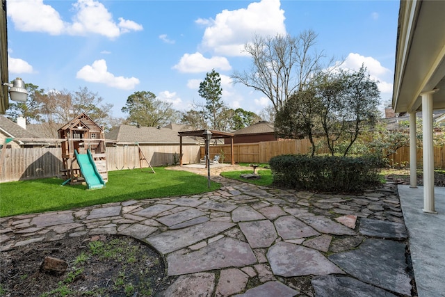 view of yard featuring a playground, a patio, and a fenced backyard