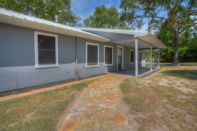81 Fm 3454th Rd, Huntsville, TX 77320 - view of front of home with a patio, stucco siding, and a metal roof