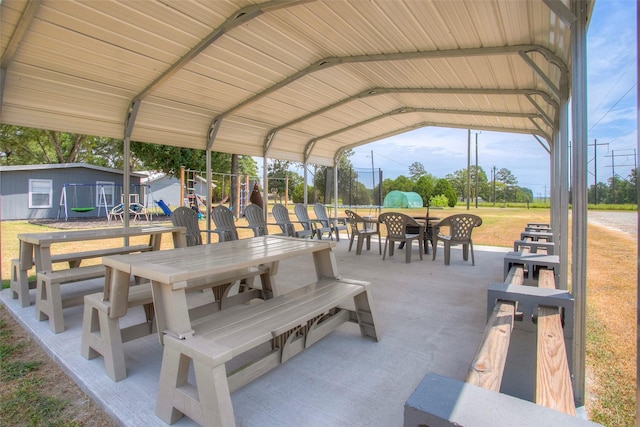 81 Fm 3454th Rd, Huntsville, TX 77320 - view of patio with outdoor dining area, a carport, and an outbuilding