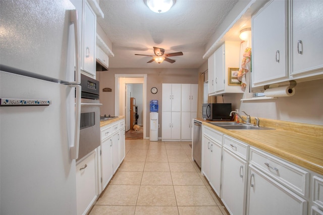 81 Fm 3454th Rd, Huntsville, TX 77320 - kitchen featuring appliances with stainless steel finishes, ceiling fan, light countertops, white cabinets, and a textured ceiling