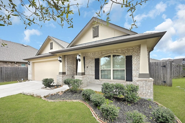 view of front of property featuring a porch, a garage, and a front lawn