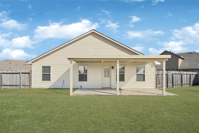 back of property with a fenced backyard, a lawn, and a patio