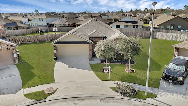 view of front of house with brick siding, fence, concrete driveway, a residential view, and a front lawn