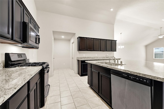 kitchen with a ceiling fan, light stone counters, appliances with stainless steel finishes, vaulted ceiling, and a sink