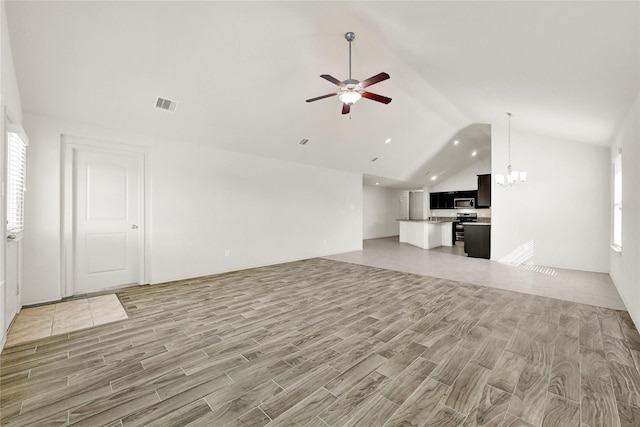 unfurnished living room with lofted ceiling, light wood-style flooring, ceiling fan with notable chandelier, and visible vents