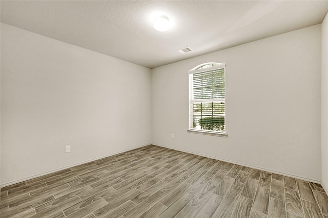 empty room featuring visible vents and wood finished floors