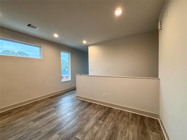 unfurnished room with dark wood-type flooring