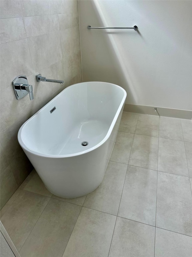 bathroom featuring tile patterned flooring, tile walls, and a washtub