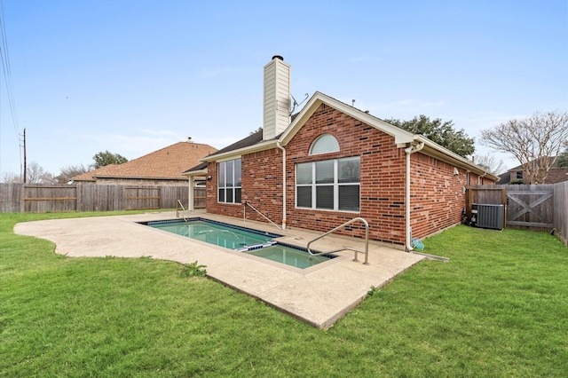 rear view of property with a fenced in pool, a patio, a yard, and central air condition unit