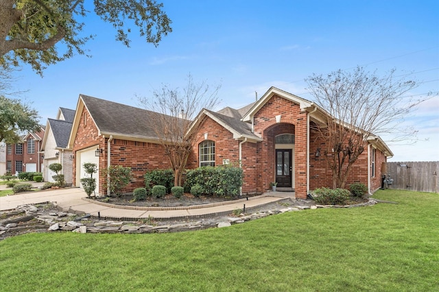 view of front of home with a garage, a shingled roof, fence, a front lawn, and brick siding