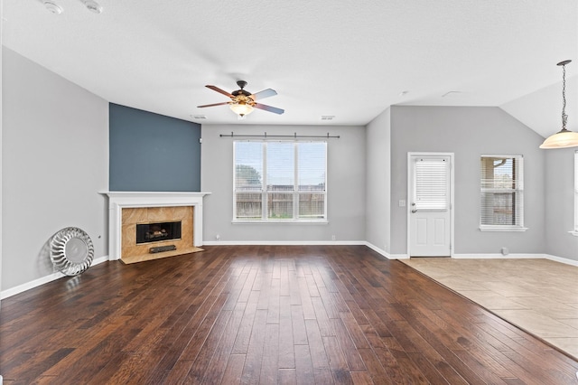 unfurnished living room featuring hardwood / wood-style floors, a high end fireplace, ceiling fan, and vaulted ceiling