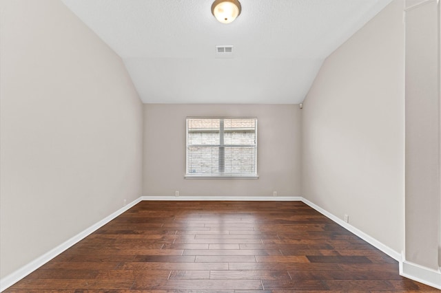 empty room with lofted ceiling and dark hardwood / wood-style floors