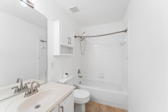 full bathroom with toilet, tiled shower / bath, a textured ceiling, vanity, and tile patterned flooring