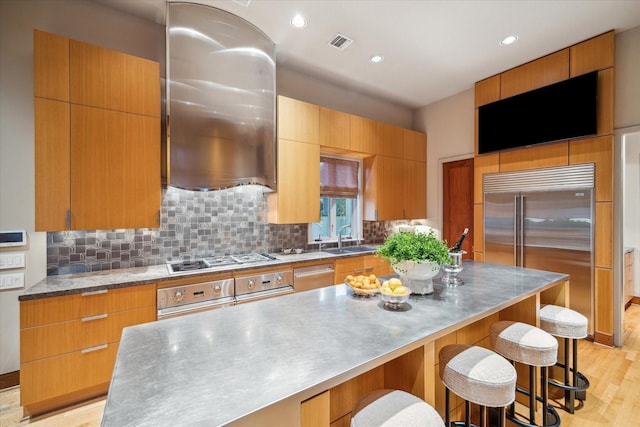 kitchen featuring stainless steel appliances, tasteful backsplash, sink, and a breakfast bar