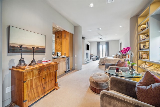 living room featuring light colored carpet, wine cooler, and ceiling fan