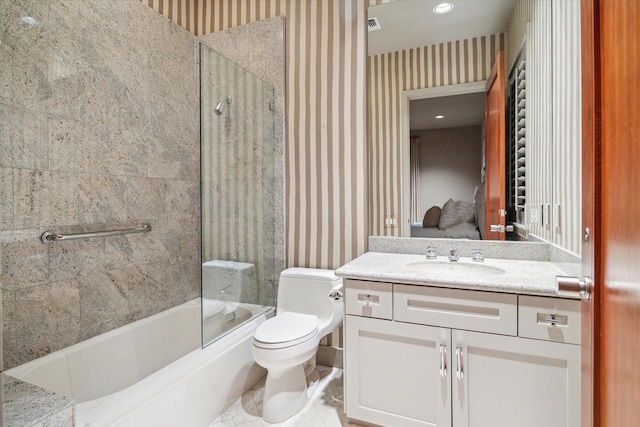 full bathroom with vanity, tiled shower / bath combo, and toilet