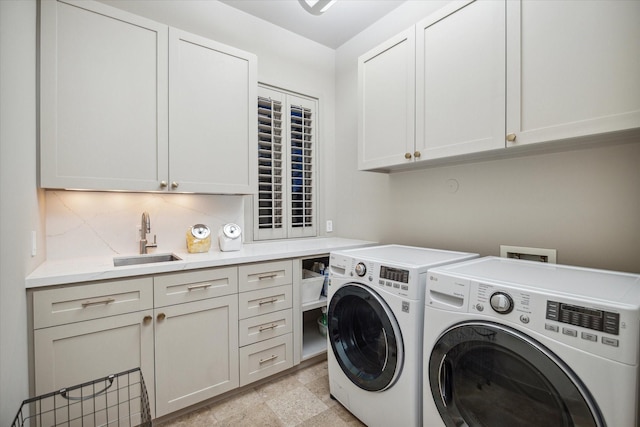 washroom featuring cabinets, sink, and washing machine and clothes dryer