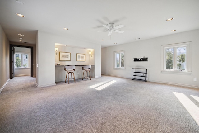 unfurnished living room with light carpet and a wealth of natural light