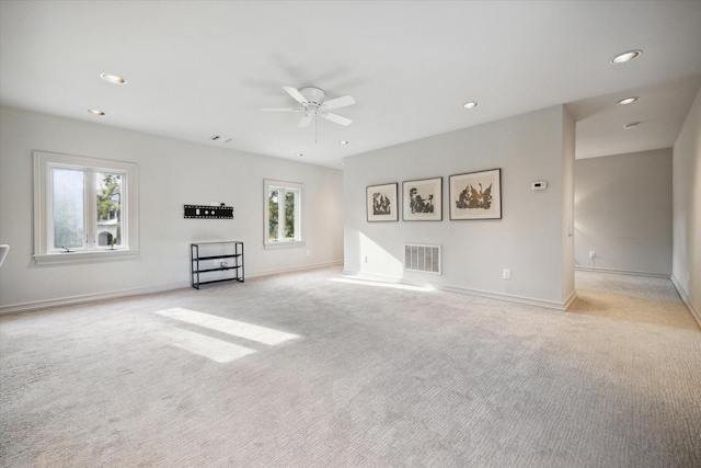 unfurnished living room with light colored carpet and ceiling fan