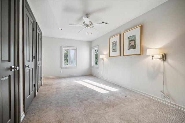 spare room with light colored carpet and ceiling fan