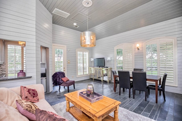 living room featuring plenty of natural light, wooden ceiling, and wood walls