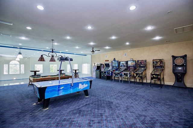 recreation room with dark colored carpet, plenty of natural light, and ceiling fan