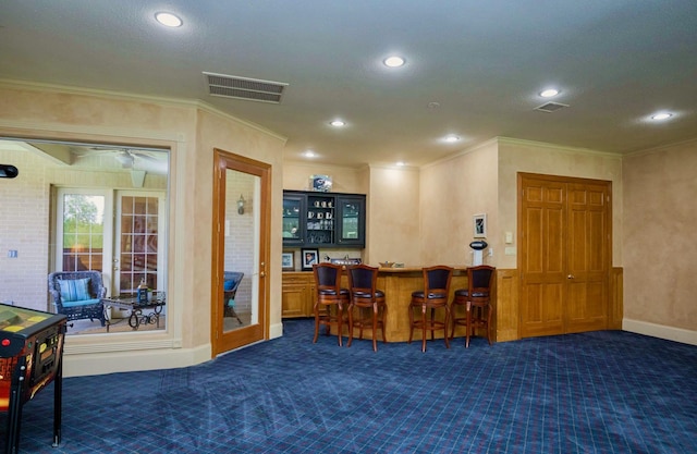 bar with crown molding and dark colored carpet