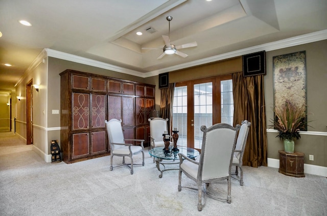 living area featuring crown molding, light colored carpet, a tray ceiling, and ceiling fan