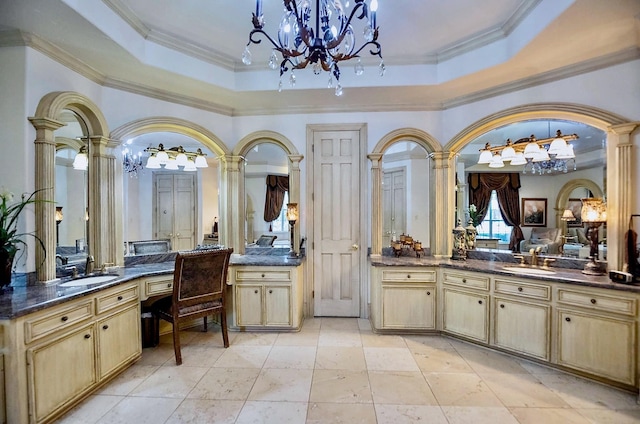 bathroom featuring ornamental molding, a tray ceiling, decorative columns, and vanity