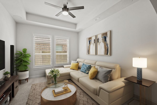 living room with carpet floors, a raised ceiling, and ceiling fan