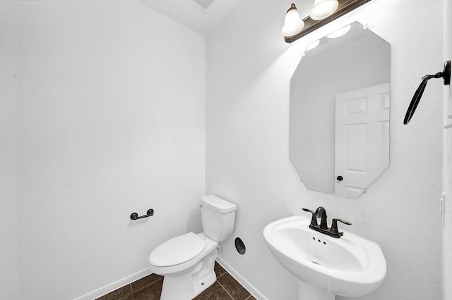 bathroom featuring toilet, tile patterned flooring, and sink