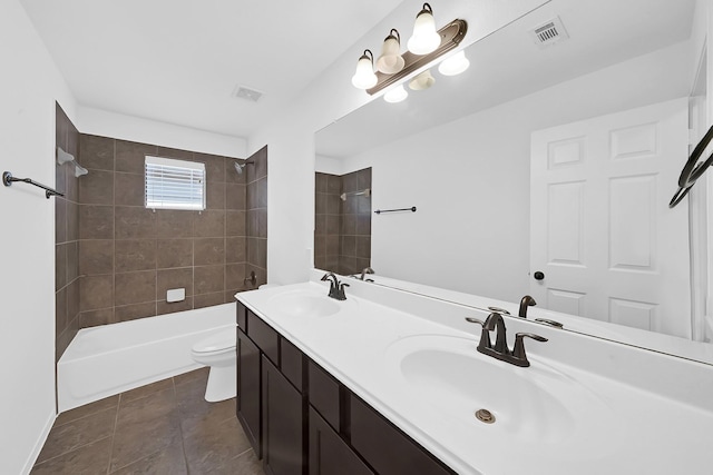 full bathroom featuring vanity, tiled shower / bath, tile patterned flooring, and toilet