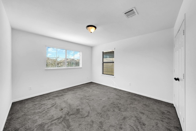 empty room with dark colored carpet