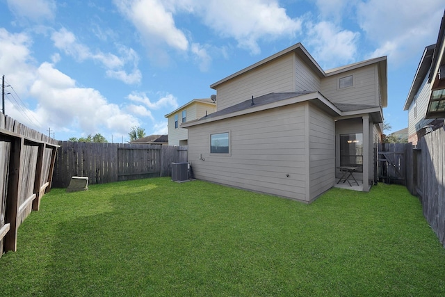 back of house with central AC unit and a lawn