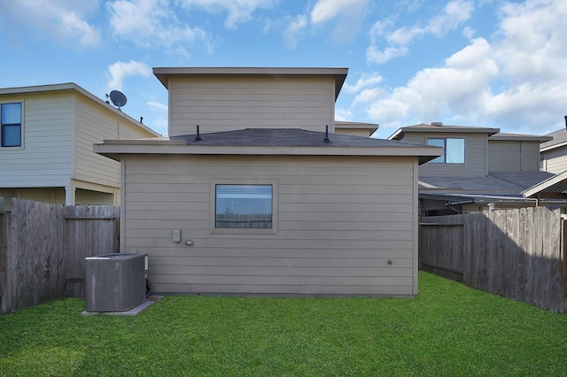 back of house with central AC and a lawn