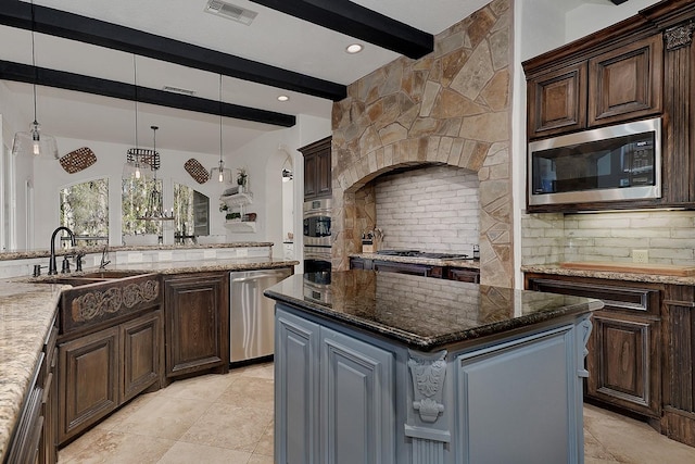 kitchen with hanging light fixtures, dark brown cabinets, stainless steel appliances, and a center island