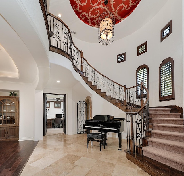 entrance foyer featuring a high ceiling, ceiling fan, and a tray ceiling