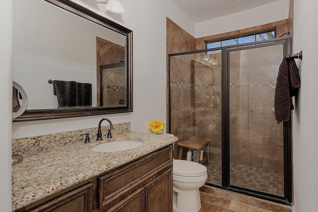 bathroom with toilet, vanity, and walk in shower